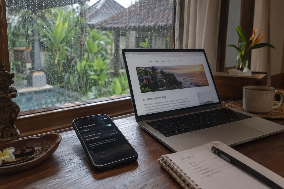 A phone provides a mobile hotspot to a laptop during a rainstorm at a Bali villa