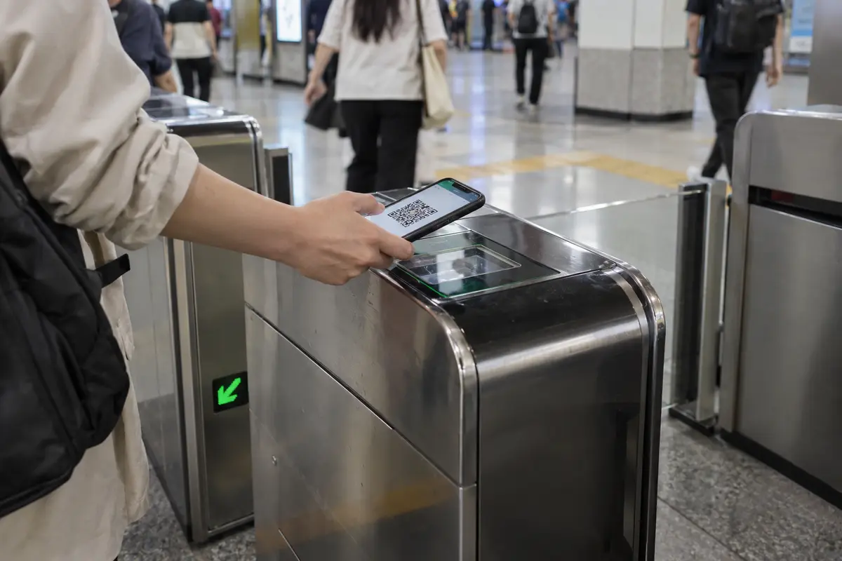 A traveler scans a phone transit code at a metro turnstile in China