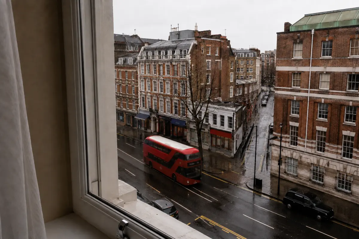 A rain-damp London street seen from a hotel window during a trip